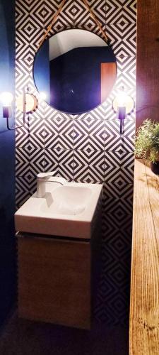 a bathroom with a sink and a mirror on a wall at L'AvantGardiste, Spacious 6 bedrooms duplex, panoramic view in Crans-Montana