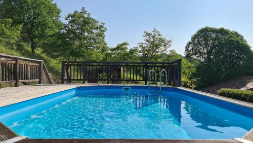 une piscine avec une terrasse en bois et une piscine bleue dans l'établissement Cosy Gîte with private pool, à Montferrand-du-Périgord