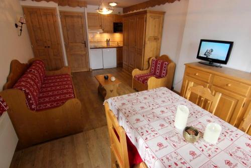 une chambre avec une table et des chaises ainsi qu'une cuisine dans l'établissement Schuss Appartements VTI, à Val Thorens