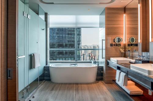 a bathroom with a tub and a large window at Hilton Jinan South Hotel & Residences in Jinan