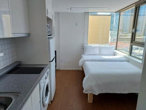 a small kitchen with two beds and a sink at 318 Stay in Seoul