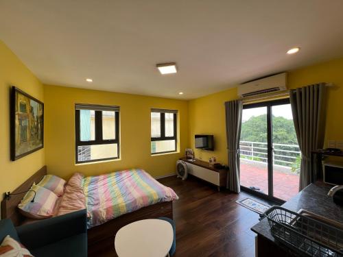 Schlafzimmer mit gelben Wänden, einem Bett und einem Balkon in der Unterkunft Bhome Văn Miếu in Hanoi