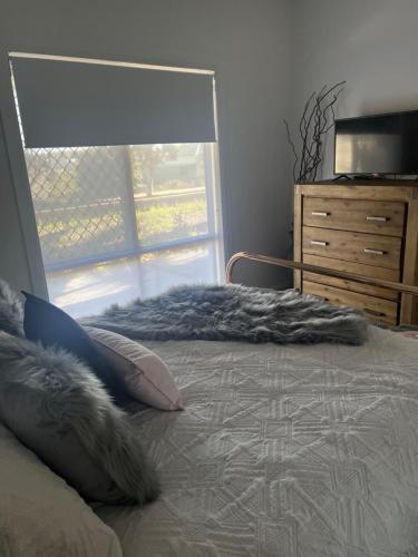 a bedroom with a bed with a window and a dresser at Little Gem On Williams in Broken Hill