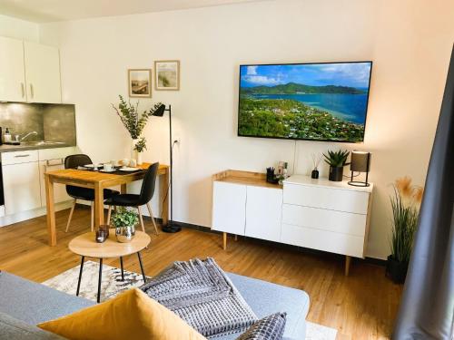 a living room with a table and a tv on the wall at Ferienwohnung Stamer in Eckernförde