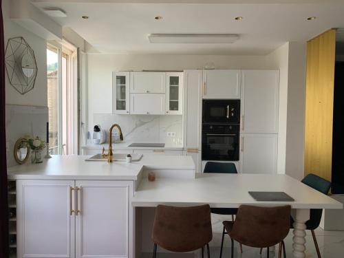 a kitchen with white cabinets and a table with chairs at Appartement avec superbe vue sur le Rhône in Vienne