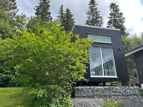 una casa negra con una ventana en una pared de piedra en Åre Travel - Villa Solbringen eller Lilla Sol, en Åre