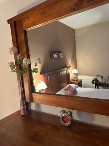 1 dormitorio con un espejo grande y un jarrón con flores en CASA RURAL LAS PALMERAS, en Tobarra