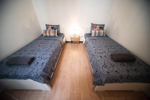 two twin beds in a room with a wooden floor at Private room By BCN Center in Barcelona