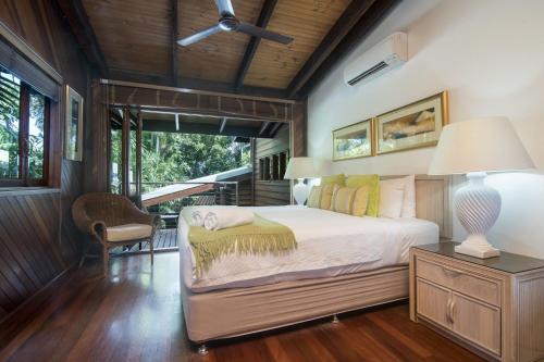 1 dormitorio con 1 cama y 1 mesa con lámpara en 19 Murphy Street, en Port Douglas