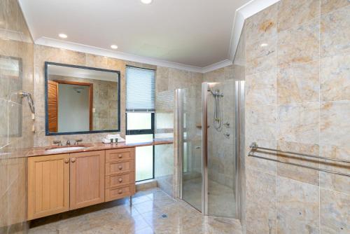 W łazience znajduje się prysznic, umywalka i lustro. w obiekcie The Point Villa 2 w mieście Port Douglas