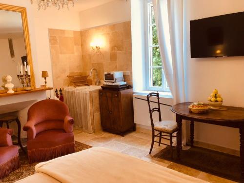 een woonkamer met een bed, een tafel en een televisie bij Chez Nelly : Escapade campagne Toulousaine in Bessières