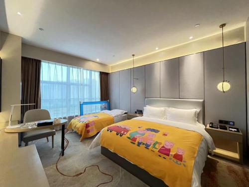 a hotel room with two beds and a desk at Qingyuan Argyle Hotel in Qingyuan