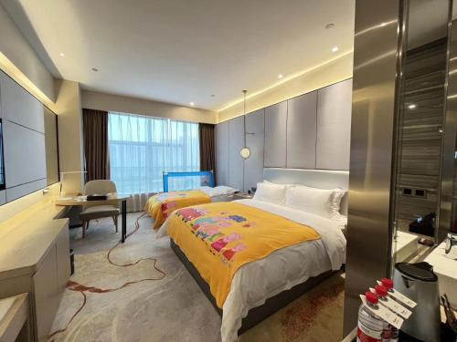a hotel room with two beds and a desk at Qingyuan Argyle Hotel in Qingyuan