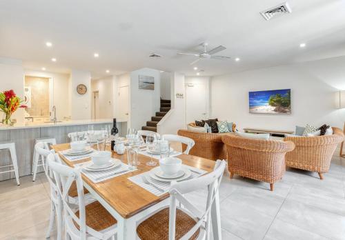 a dining room and living room with a table and chairs at 7 Plantation House in Port Douglas