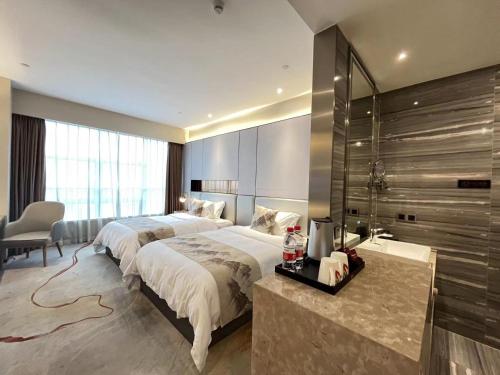 a hotel room with two beds and a desk at Qingyuan Argyle Hotel in Qingyuan