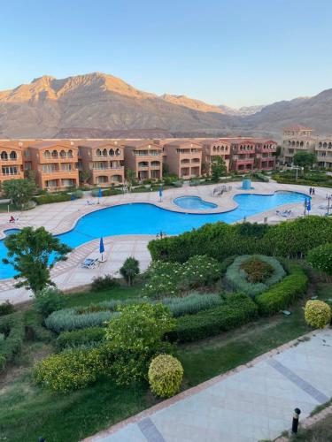 an overhead view of a resort with two swimming pools at Chalet Porto El Sokhna Panorama area -2 bedroom- excellent view شاليه ببورتو السخنة - منطقة البانوراما - غرفتين وريسبشن فيو البسين والجولف والجبال والبحر- Family & young people over 30 years only in Ain Sokhna