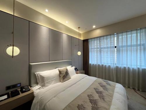 a bedroom with a large bed and a window at Qingyuan Argyle Hotel in Qingyuan