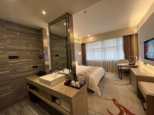 a bathroom with a bed and a sink and a mirror at Qingyuan Argyle Hotel in Qingyuan
