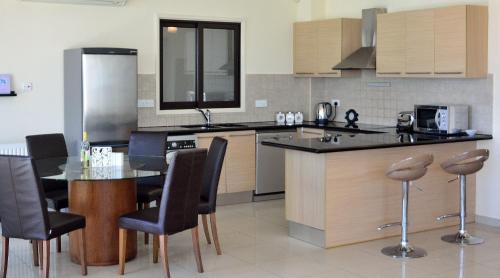 a kitchen with a table and some chairs in it at Villa Aris in Ayios Theodhoros