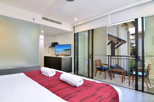 - une chambre avec un grand lit et un balcon dans l'établissement 207 Temple By The Sea, à Port Douglas