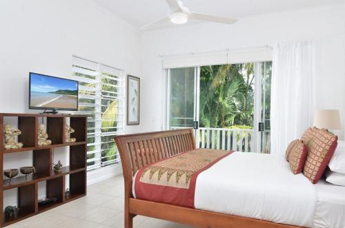 1 dormitorio con cama y ventana grande en Beach Villa 5, en Port Douglas