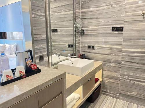 a bathroom with a sink and a large mirror at Qingyuan Argyle Hotel in Qingyuan