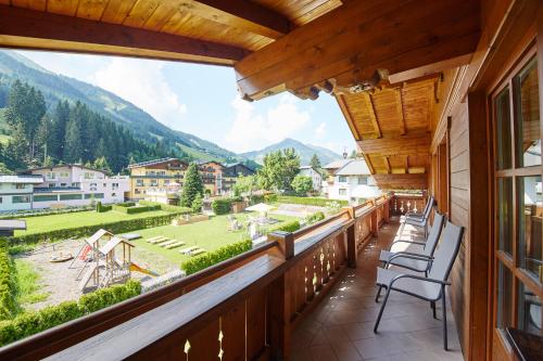 a balcony with chairs and a view of the mountains at Appartements Living Saalbach in Saalbach Hinterglemm