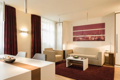 a living room with a couch and a table at Living Apartments Ludwigshafen in Ludwigshafen am Rhein
