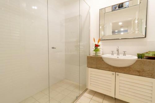 uma casa de banho com um lavatório e uma cabina de duche em vidro. em Beach Villa 3 em Port Douglas