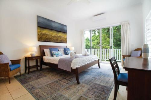 um quarto com uma cama com um quadro na parede em Beach Villa 3 em Port Douglas