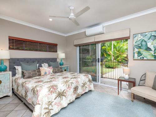 a bedroom with a bed and a sliding glass door at Blue Sage in Port Douglas