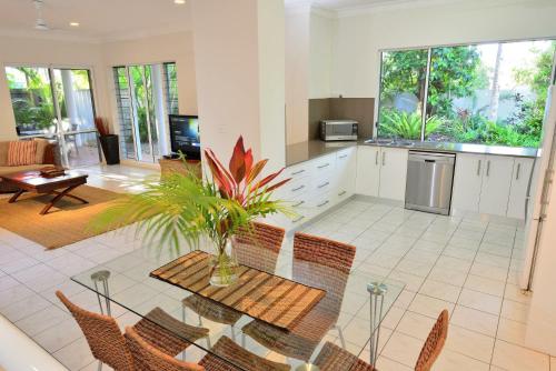 a kitchen with a table and chairs in a room at Coral Drive Retreat in Port Douglas