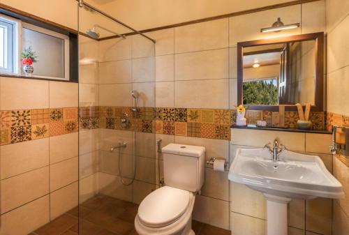 a bathroom with a toilet and a sink at Willow Hill by Nature Resorts in Ooty