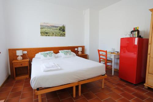 1 dormitorio con 1 cama y nevera roja en Agriturismo Spolert Winery, en Prepotto