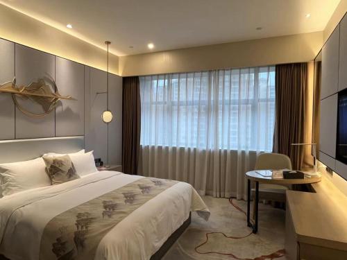 a bedroom with a large bed and a television at Qingyuan Argyle Hotel in Qingyuan