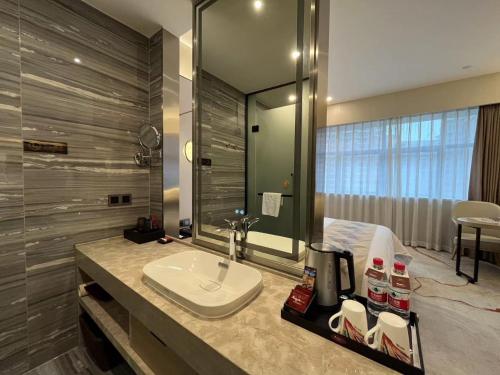 a bathroom with a sink and a mirror at Qingyuan Argyle Hotel in Qingyuan