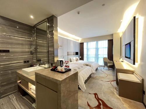 a hotel room with a bed and a sink at Qingyuan Argyle Hotel in Qingyuan
