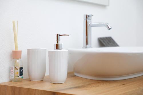 three white cups sitting on a counter next to a sink at Agriturismo Spolert Winery in Prepotto