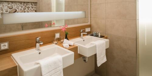 a bathroom with two sinks and a mirror at Living Apartments Ludwigshafen in Ludwigshafen am Rhein