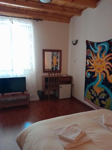 1 dormitorio con 1 cama y TV en una habitación en Ξενώνας questhouse Electra isari, en Isaris