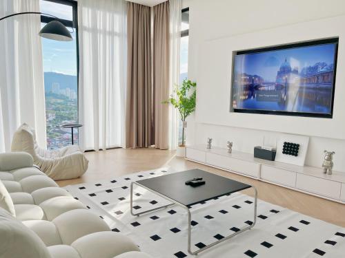 uma sala de estar com um sofá branco e uma televisão em Beacon Executive@Penang Georgetown em George Town