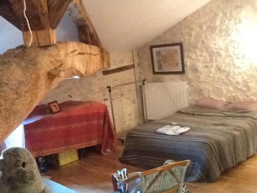 a bedroom with a bed and a table in a cave at une fermette climatisée en pleine nature in Moirax