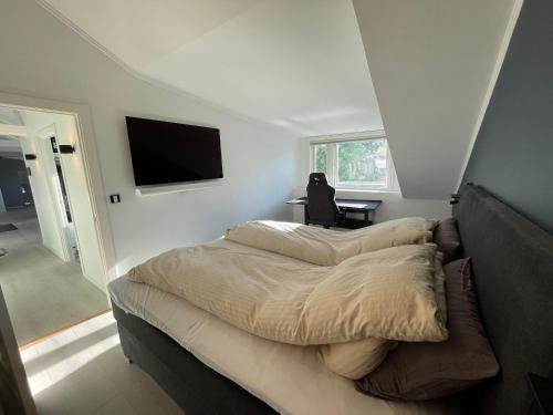 a bedroom with two beds and a flat screen tv at Erling Skjalgssons gate 32a in Oslo