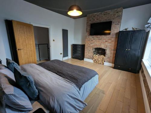 a bedroom with a large bed and a fireplace at Urban Zen Den in Town Moor