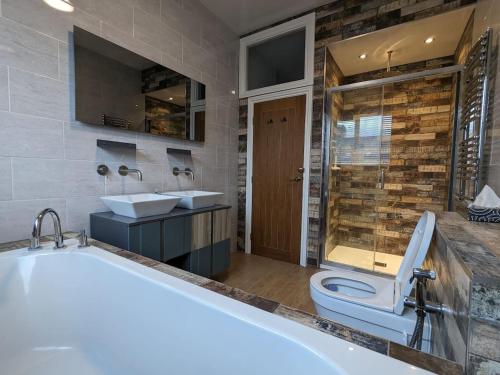 a bathroom with a tub and a toilet and a sink at Urban Zen Den in Town Moor