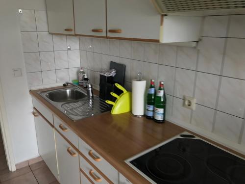 a kitchen counter with a sink and bottles of wine at 2 Zimmer Wohnung zum Auspowern oder Erholen. in Erkrath