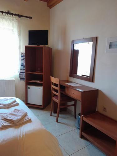 1 dormitorio con escritorio y 1 cama con espejo en Ξενώνας questhouse Electra isari, en Isaris