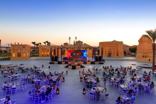 a group of people sitting in chairs in front of a stage at Neverland City Hurghada - Pickalbatros in Hurghada