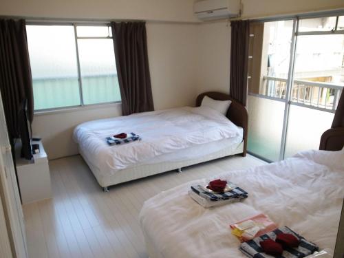 a hotel room with two beds and a balcony at Shimakaigetsu in Sumoto