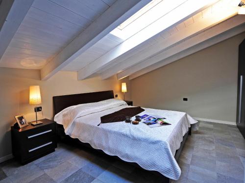 una camera con un grande letto e un lucernario di Mansarda Di Pianello a Pianello Del Lario